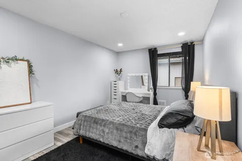 a bedroom with a large bed and a lamp on table