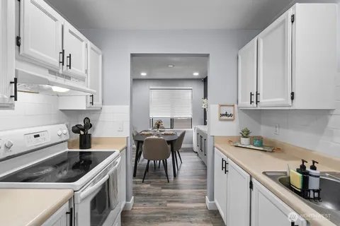 a kitchen with white cabinets and white appliances