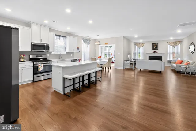 a large kitchen with stainless steel appliances lots of counter space and windows