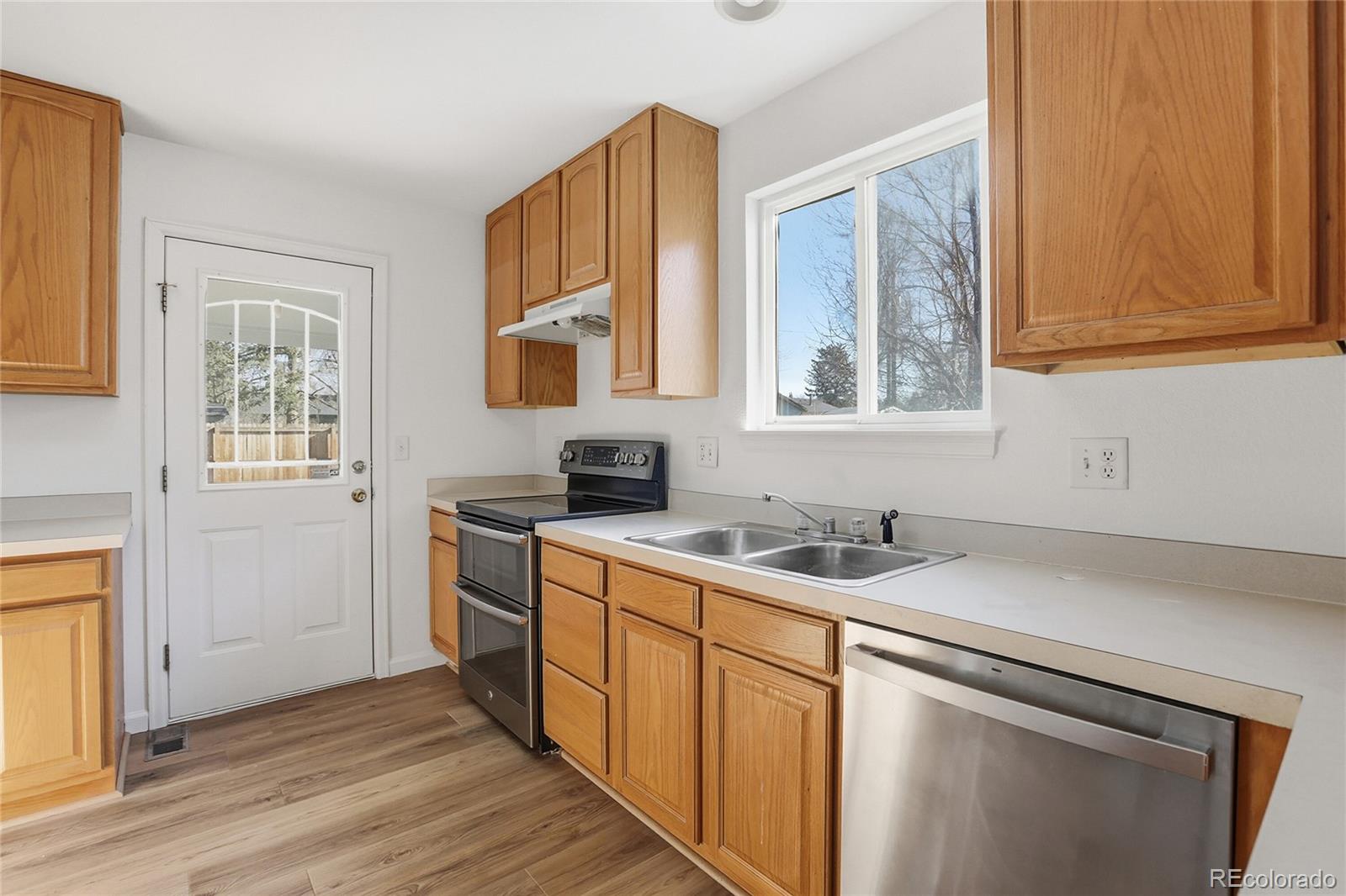 3736 South Inca Street Englewood, CO 80110 - Photo 10 of 31 a kitchen with a sink cabinets wooden floor and a window