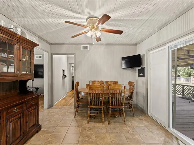 a view of a dining room with furniture and a chandelier fan