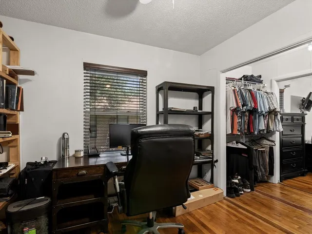 a view of a workspace with furniture and a window