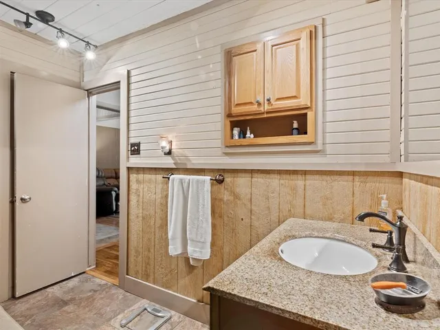 a bathroom with a granite countertop sink and a mirror