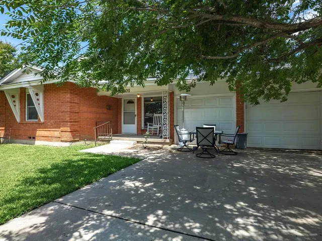 a view of a chair and table in backyard of the house