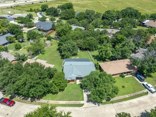 an aerial view of a house with a garden and trees