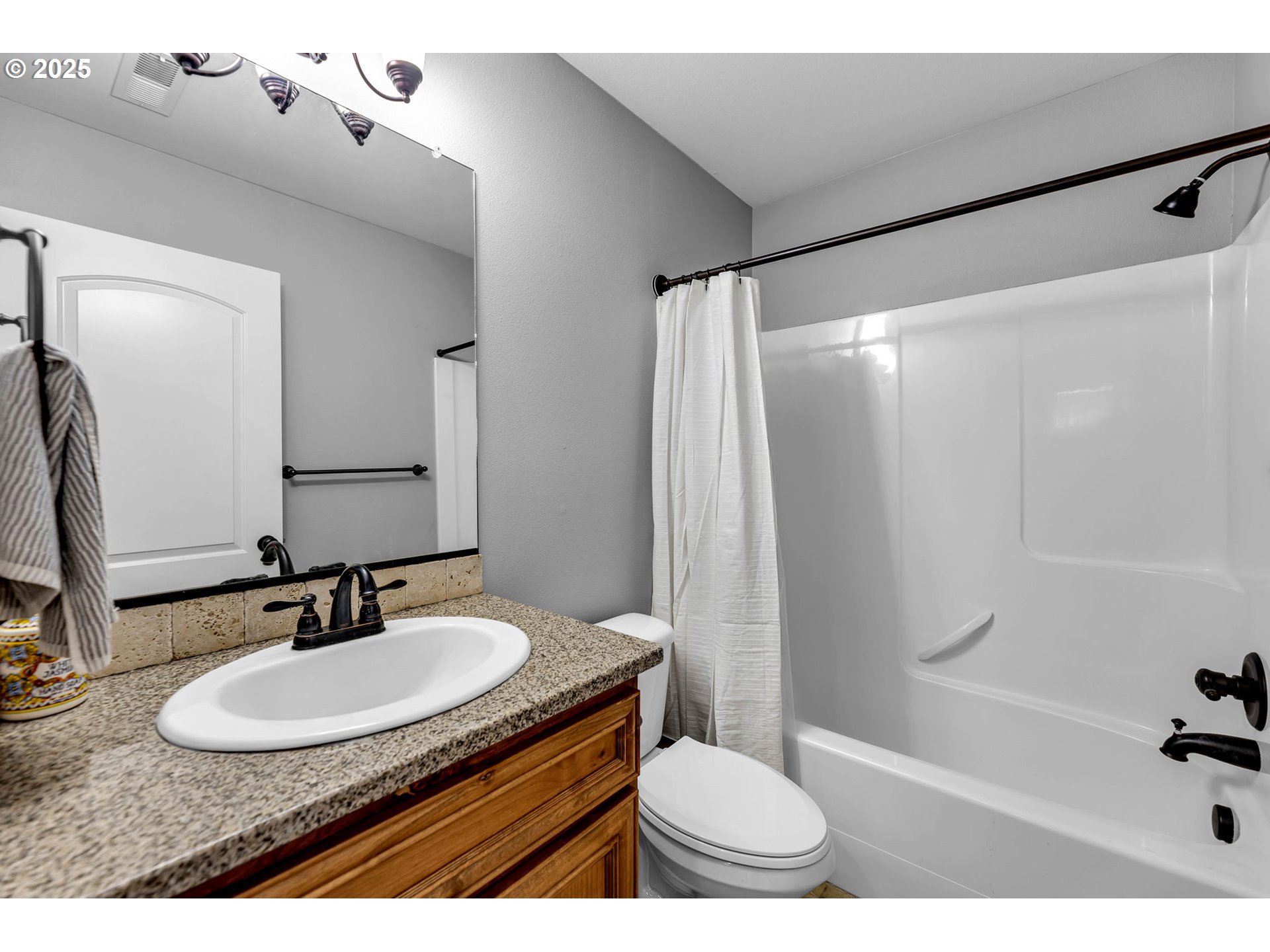 217 North 33rd Court Ridgefield, WA 98642 - Photo 21 of 35 a bathroom with a granite countertop sink and a mirror