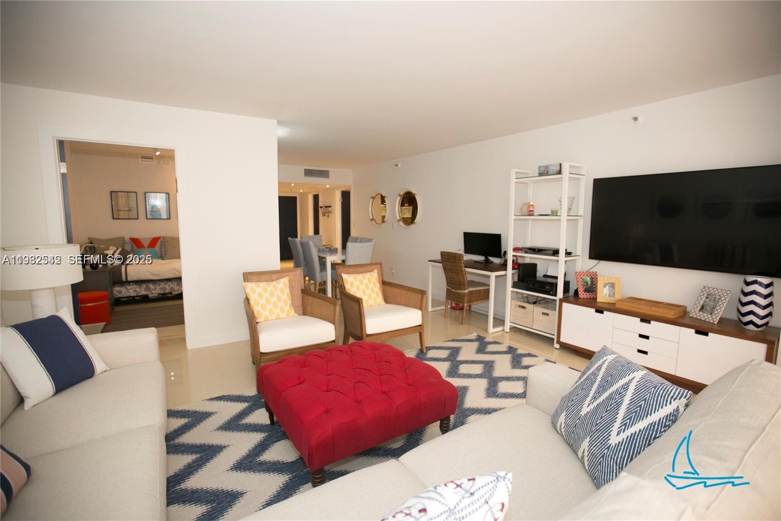 8877 Collins Avenue, Unit 805 Surfside, FL 33154 - Photo 14 of 30 a living room with furniture and a flat screen tv