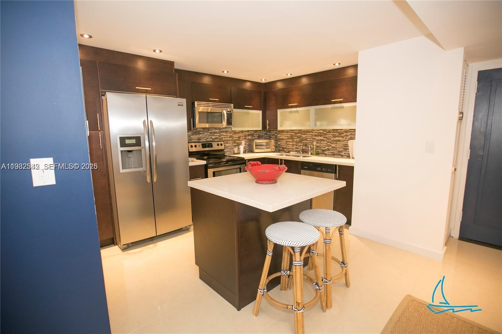 8877 Collins Avenue, Unit 805 Surfside, FL 33154 - Photo 6 of 30 a kitchen with stainless steel appliances a refrigerator and a stove