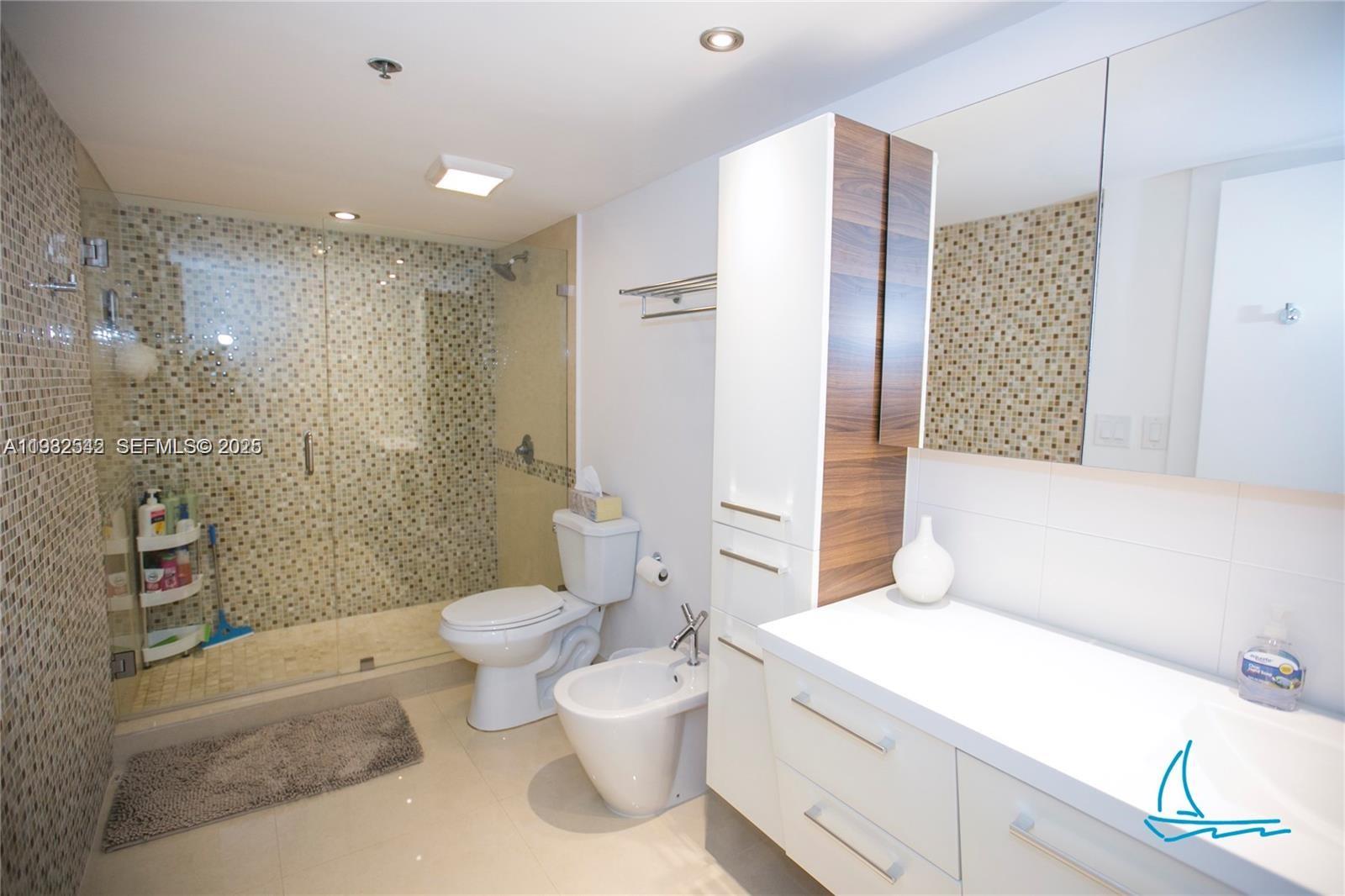 8877 Collins Avenue, Unit 805 Surfside, FL 33154 - Photo 10 of 30 a bathroom with a sink a toilet and shower