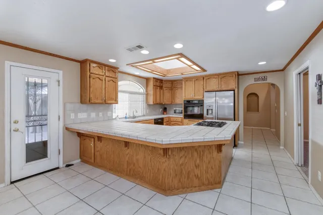 a kitchen with stainless steel appliances granite countertop a stove a sink and a refrigerator