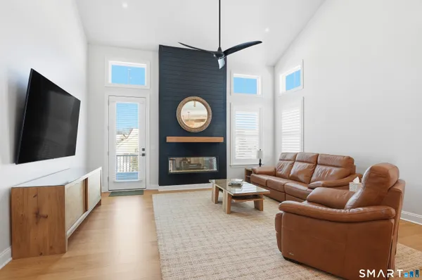 a living room with furniture a flat screen tv and a fireplace