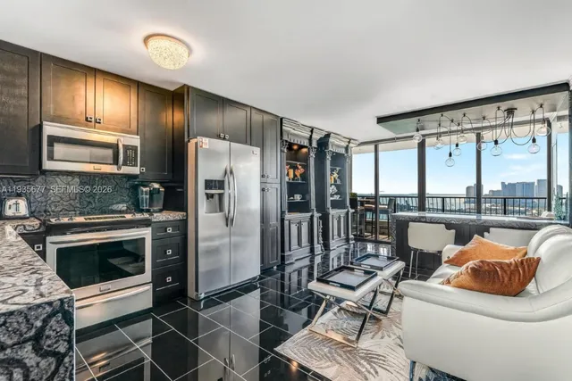 a kitchen with stainless steel appliances kitchen island granite countertop a refrigerator stove and sink