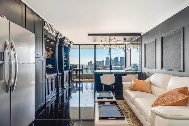 a living room with furniture a large window and stainless steel appliances
