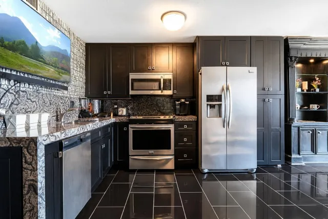 a kitchen with granite countertop a refrigerator and a sink