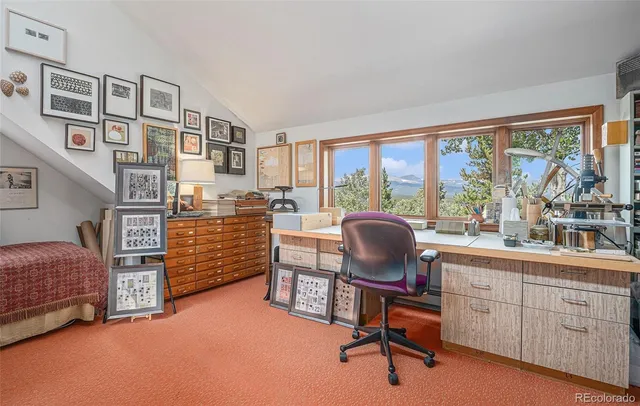 a view of a workspace with furniture and a window