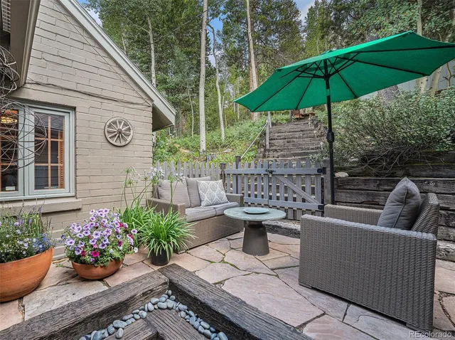 a front view of a house with yard and trees in the background