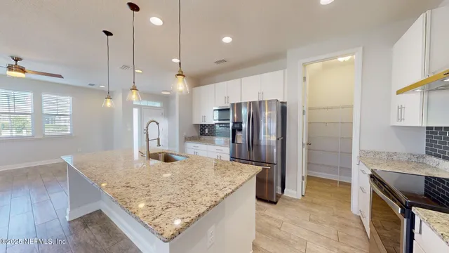 a kitchen with kitchen island a counter top space appliances and a center island