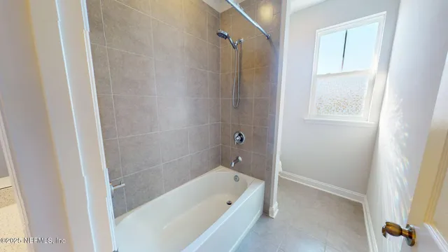 a bathroom with a tub shower and a sink