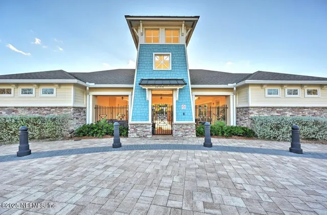 a view of a brick house with many windows and plants