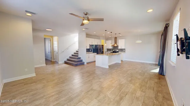 a view of a kitchen with furniture and wooden floor