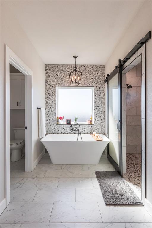 107 Kleingrass Road Abilene, TX 79606 - Photo 14 of 33 Freestanding soaking tub with floor-mounted faucet, complemented by a mosaic tile accent wall