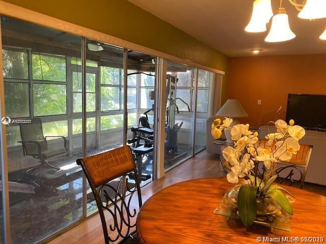 3448 Spring Bluff Place, Unit 27 Lauderhill, FL 33319 - Photo 12 of 24 a view of a dining room with furniture a chandelier and wooden floor