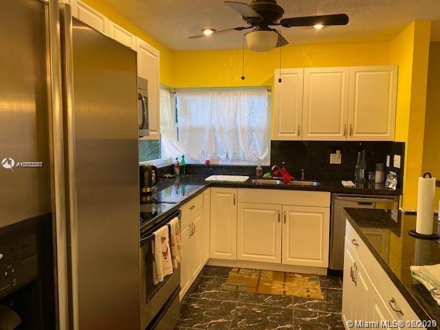 3448 Spring Bluff Place, Unit 27 Lauderhill, FL 33319 - Photo 9 of 24 a kitchen with stainless steel appliances granite countertop a refrigerator a stove and a sink