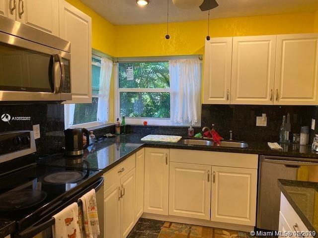 3448 Spring Bluff Place, Unit 27 Lauderhill, FL 33319 - Photo 10 of 24 a kitchen with stainless steel appliances a sink a stove and white cabinets