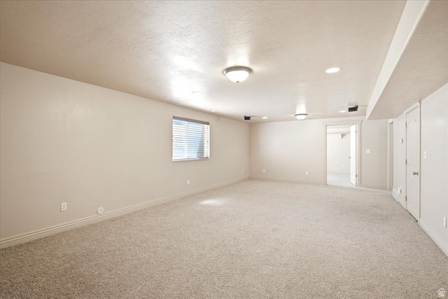 1089 West 2325th Street North Layton, UT 84041 - Photo 27 of 40 Spacious room featuring neutral paint, light-toned carpet flooring, recessed lighting, and a window with blinds