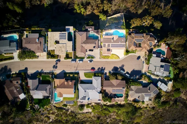 an aerial view of residential houses with outdoor space and parking