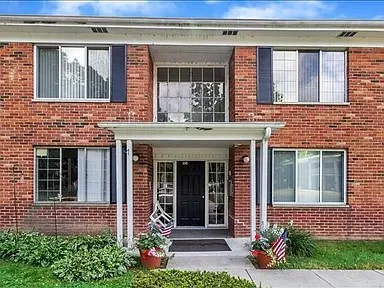 a front view of a brick house with a yard