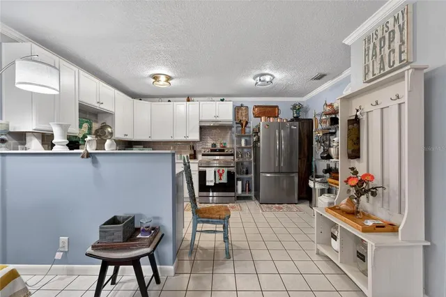 a living room with furniture a rug and kitchen view