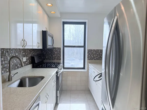 a kitchen with stainless steel appliances granite countertop a refrigerator and a sink