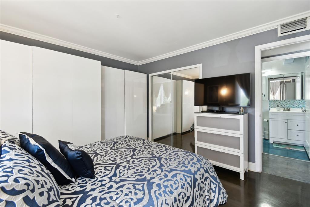 255 Dolphin Point, Unit 207 Clearwater Beach, FL 33767 - Photo 26 of 69 a bedroom with a bed and flat screen tv