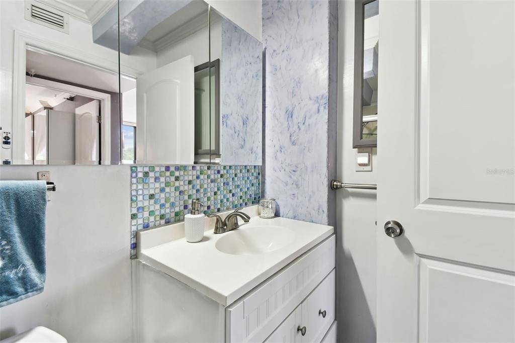 255 Dolphin Point, Unit 207 Clearwater Beach, FL 33767 - Photo 29 of 69 a bathroom with a sink a toilet and shower