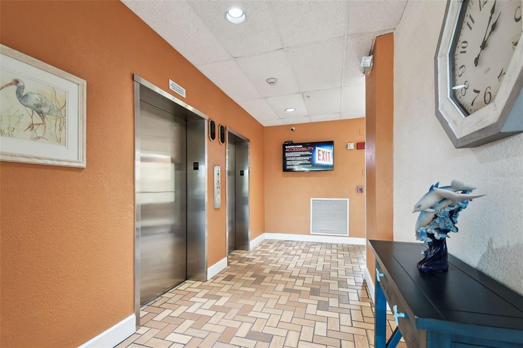 255 Dolphin Point, Unit 207 Clearwater Beach, FL 33767 - Photo 33 of 69 a bedroom with a bed and a table with potted plant