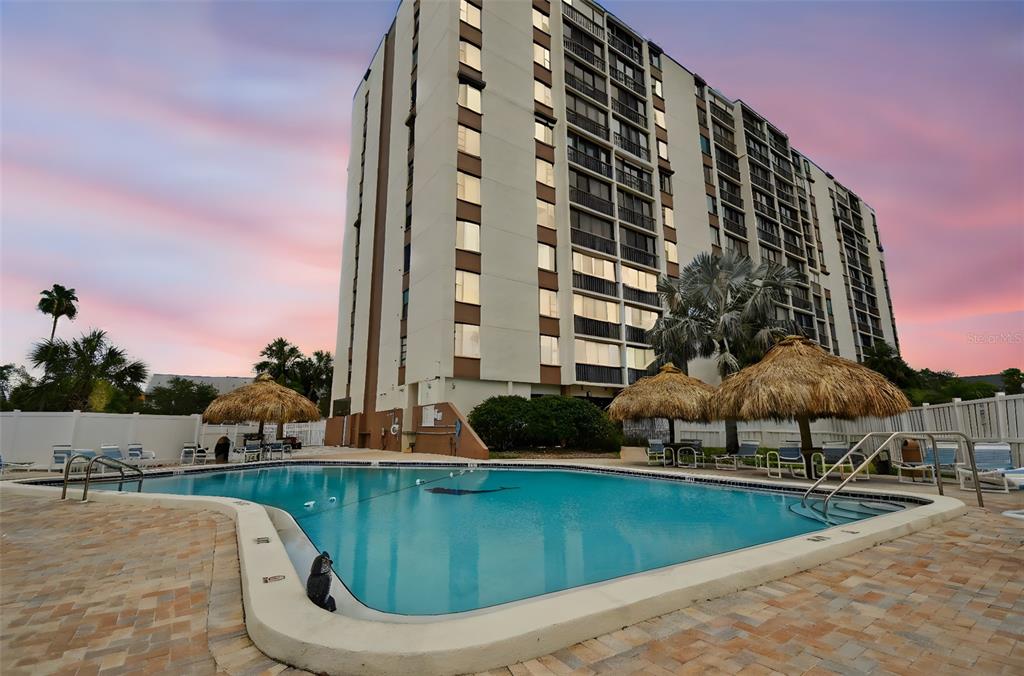 255 Dolphin Point, Unit 207 Clearwater Beach, FL 33767 - Photo 4 of 69 a view of a swimming pool with a yard