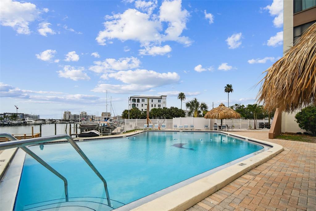 255 Dolphin Point, Unit 207 Clearwater Beach, FL 33767 - Photo 41 of 69 a view of a swimming pool with outdoor seating