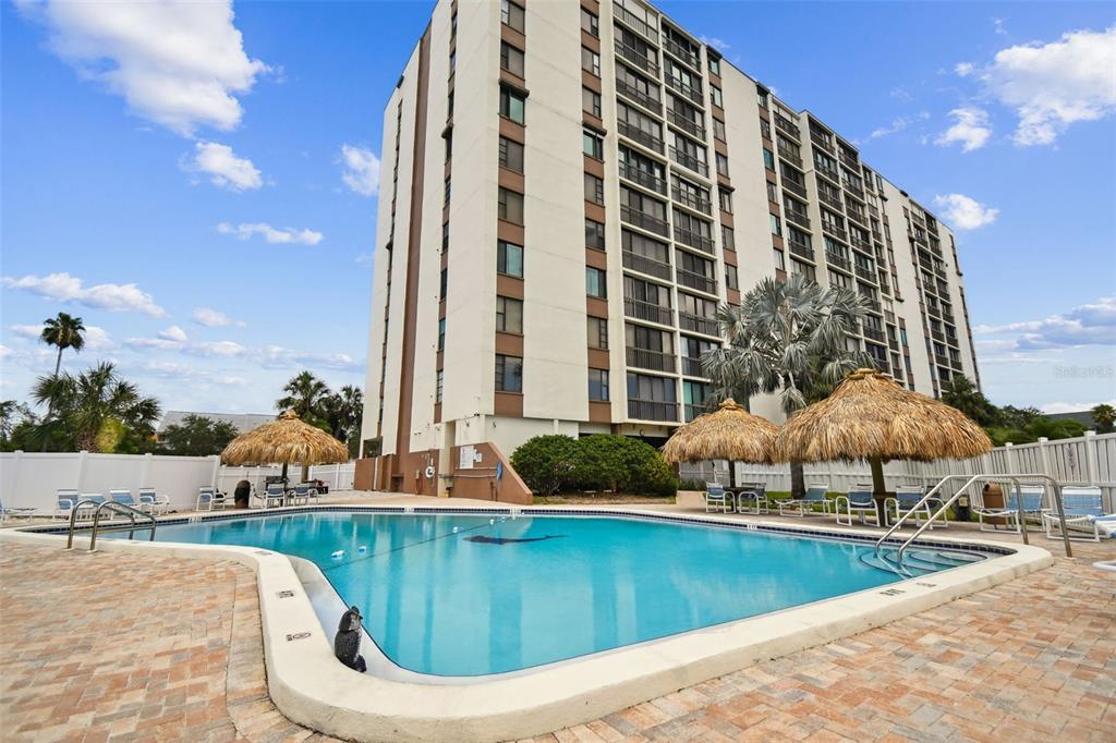 255 Dolphin Point, Unit 207 Clearwater Beach, FL 33767 - Photo 42 of 69 a view of a swimming pool with a lounge chairs