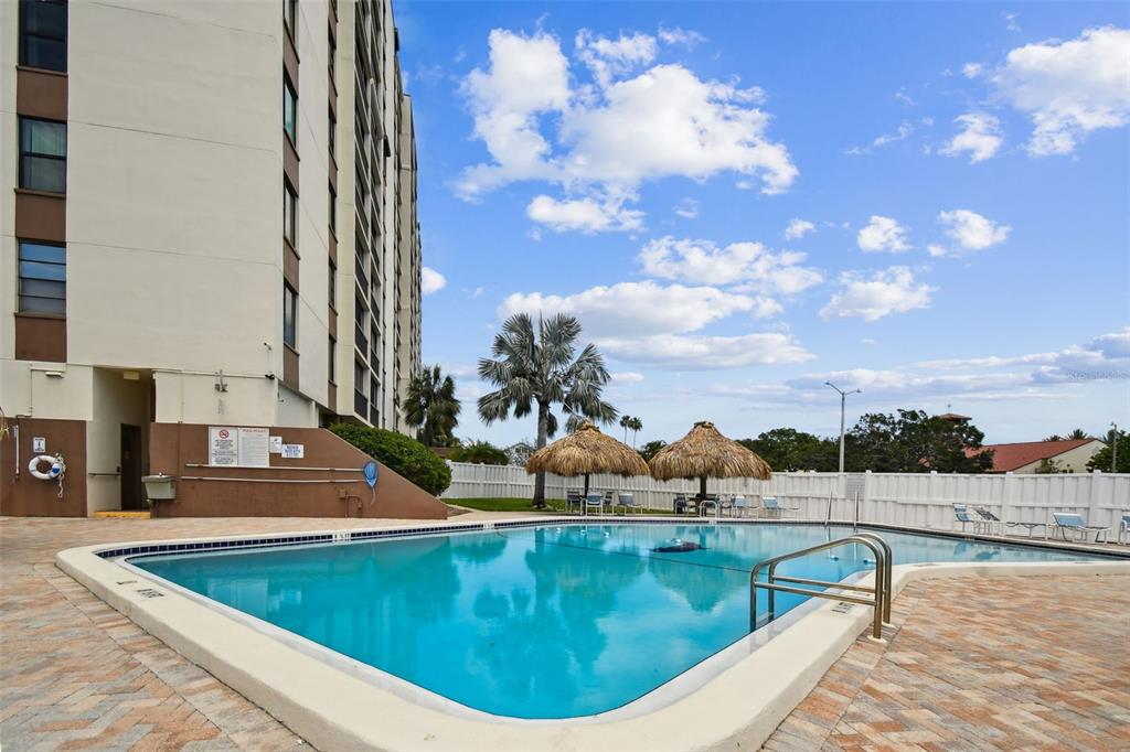255 Dolphin Point, Unit 207 Clearwater Beach, FL 33767 - Photo 44 of 69 a view of a swimming pool with a lounge chairs