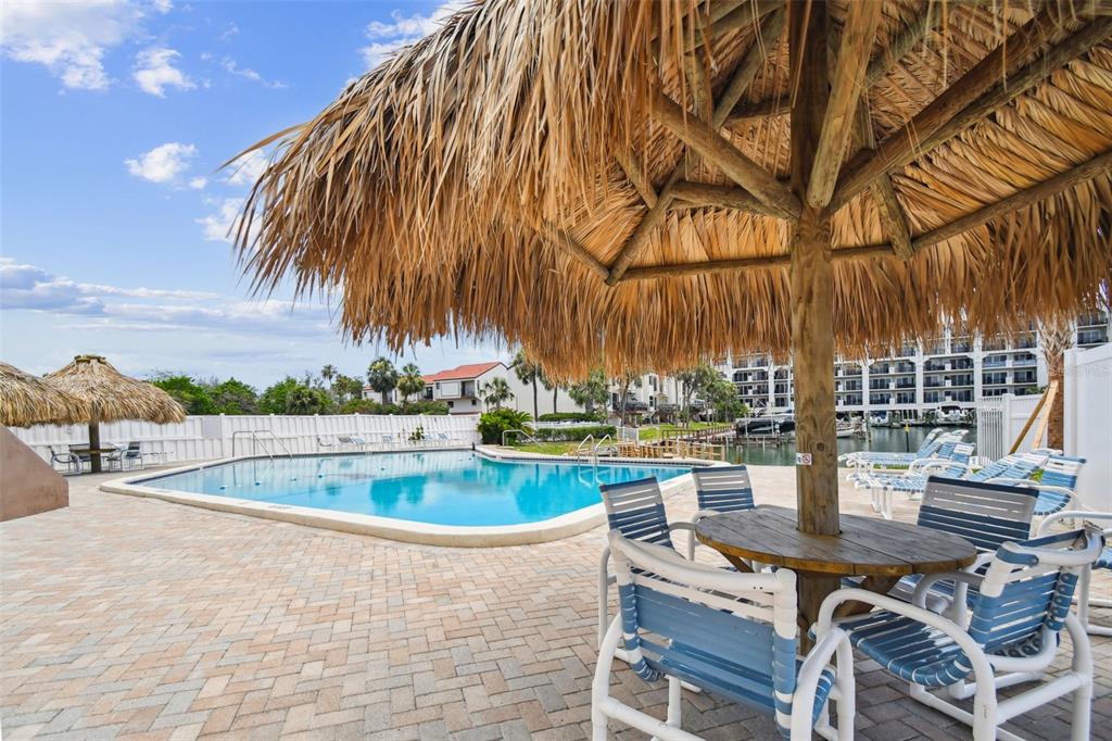 255 Dolphin Point, Unit 207 Clearwater Beach, FL 33767 - Photo 45 of 69 a view of a swimming pool with outdoor seating and plants