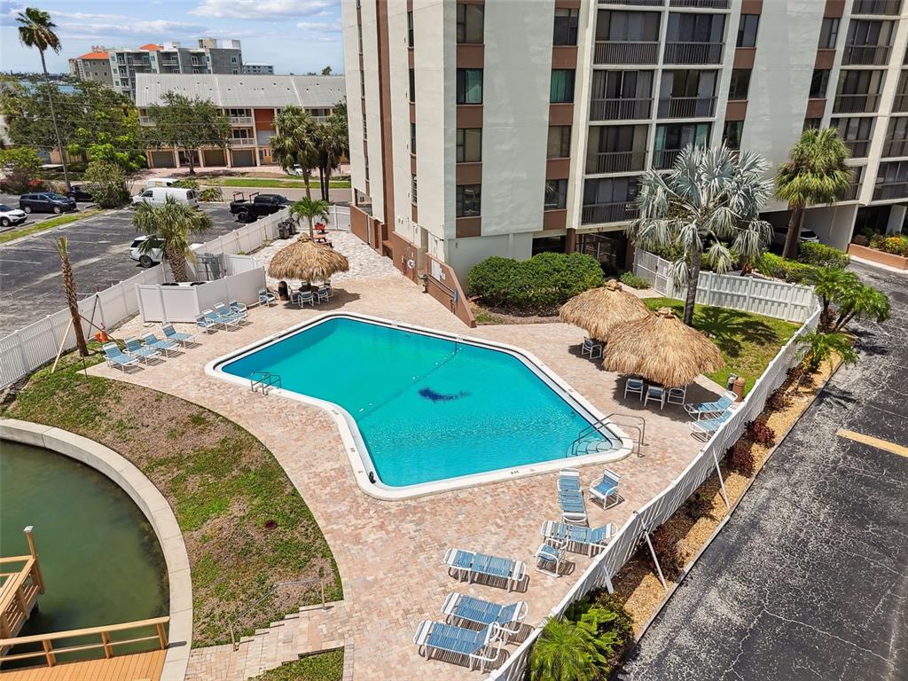255 Dolphin Point, Unit 207 Clearwater Beach, FL 33767 - Photo 47 of 69 a view of a swimming pool with a lounge chairs