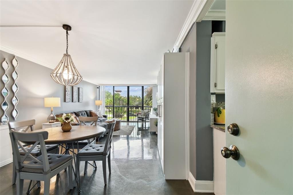 255 Dolphin Point, Unit 207 Clearwater Beach, FL 33767 - Photo 6 of 69 a dining room with furniture a chandelier and window