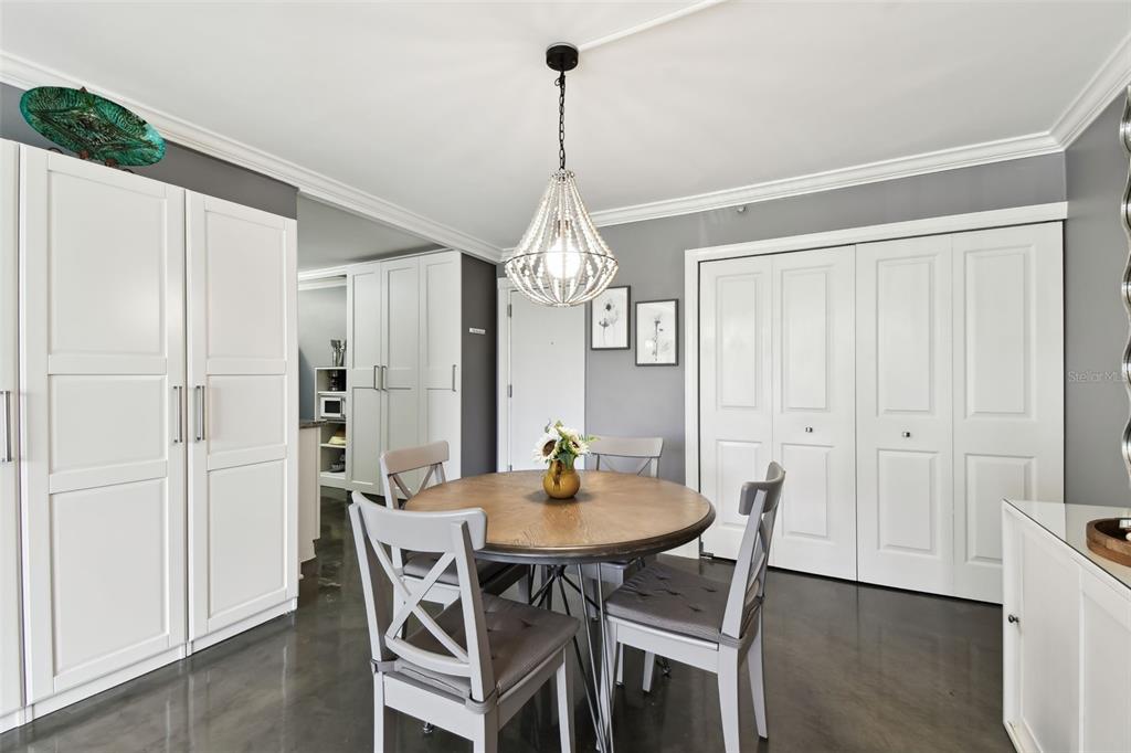 255 Dolphin Point, Unit 207 Clearwater Beach, FL 33767 - Photo 10 of 69 a dining room with furniture a chandelier and wooden floor