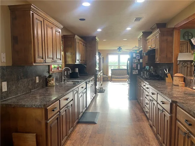 a kitchen with counter top space a sink wooden floor and stainless steel appliances