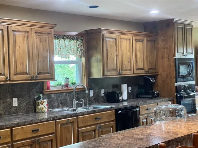 a kitchen with granite countertop a stove a sink and a counter space