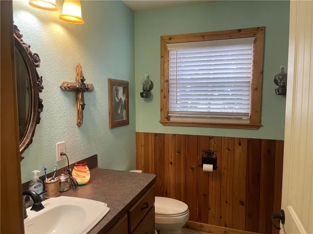 a bathroom with a sink a toilet and mirror