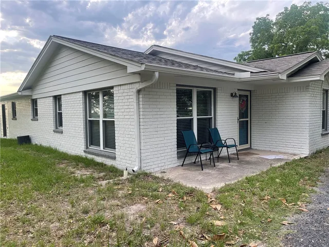 a view of a chair and table in backyard of the house