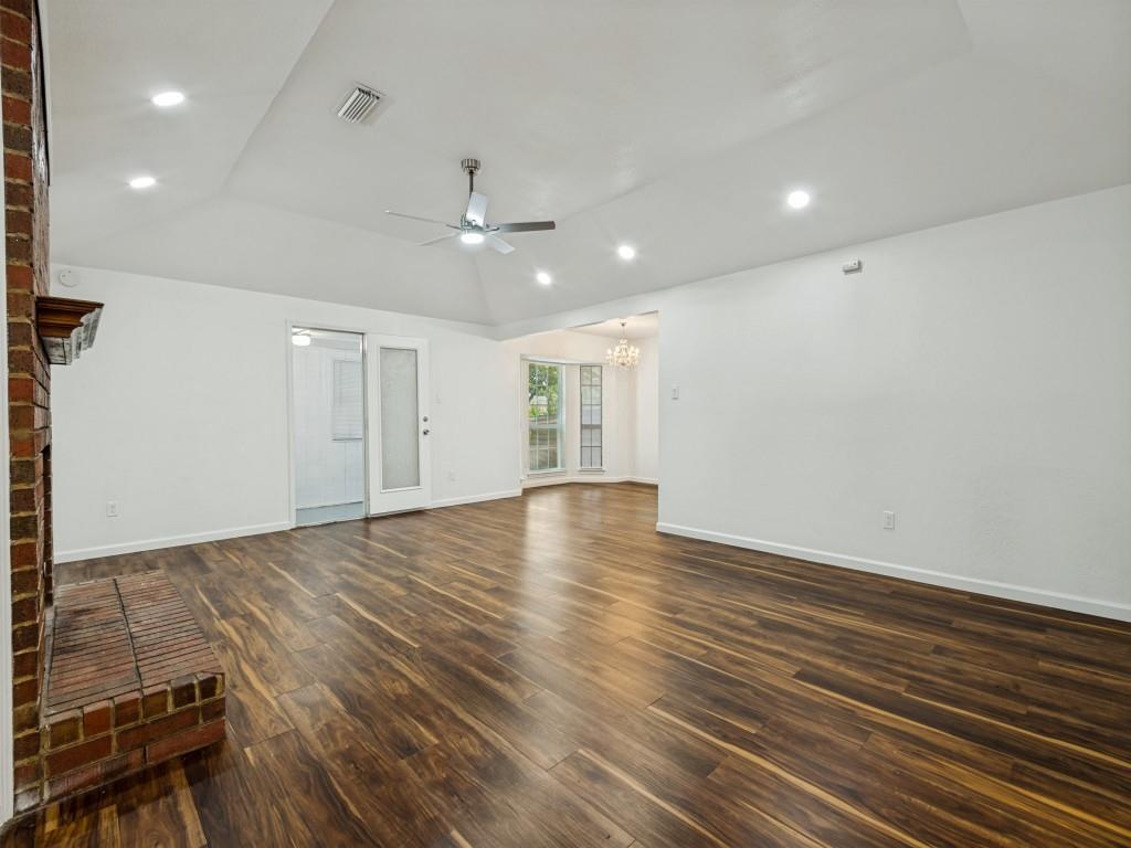 3716 Royal Valley Road Grand Prairie, TX 75052 - Photo 4 of 25 Spacious living area featuring wood-finish flooring, a brick fireplace, a vaulted ceiling with recessed lighting, and a ceiling fan