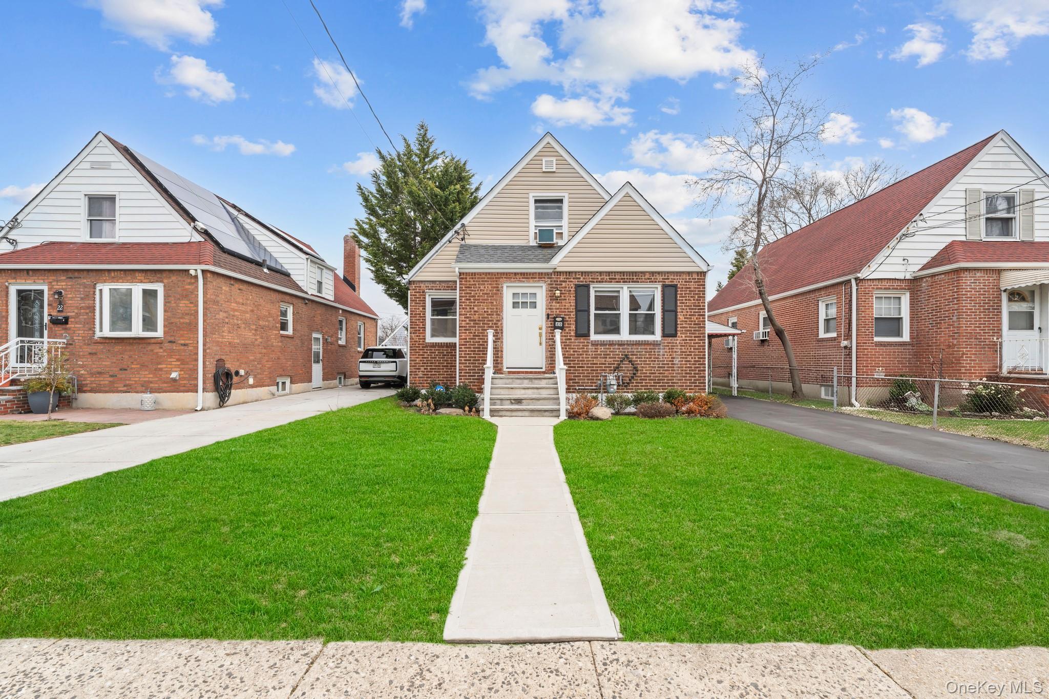 a front view of a house with a garden and yard